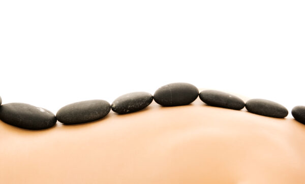 Pierres chaudes de massage disposées sur le dos d'une personne